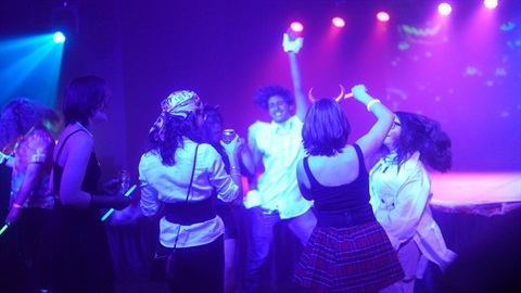 Young people dressed in halloween costumes dancing and enjoying themselves at 2023 Glitter and Glow.