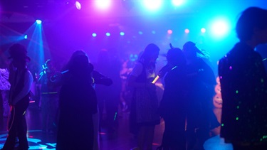 Young people dancing and socialising on the dance floor.