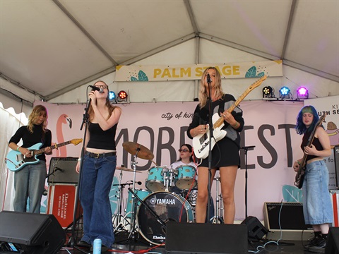 Five band members performing on stage 