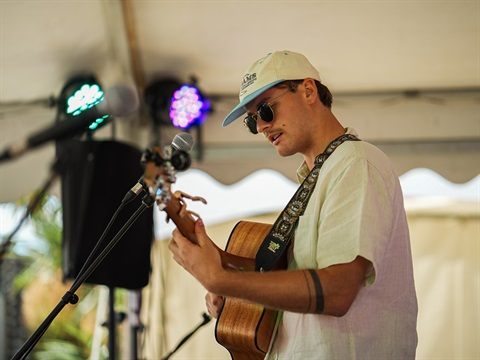 young person playing guitar on stage 