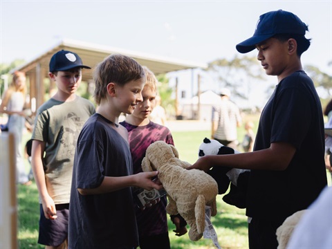 volunteer handing a prize to another young person