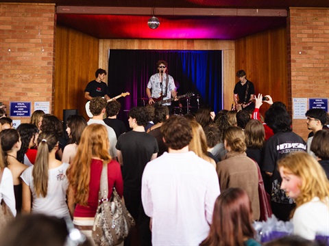 band performing on stage with audience watching